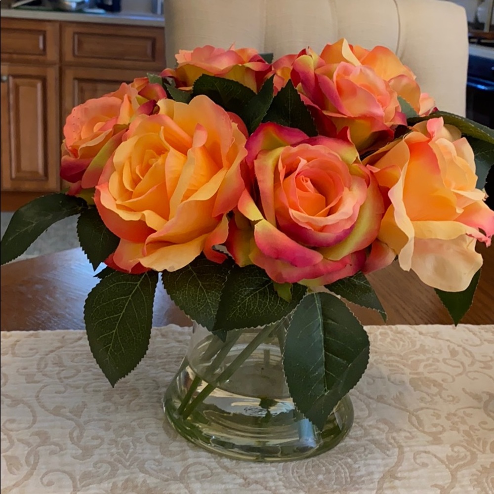 Faux rose flower arrangement with glass vase.